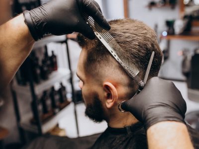 Client doing hair cut at a barber shop salon